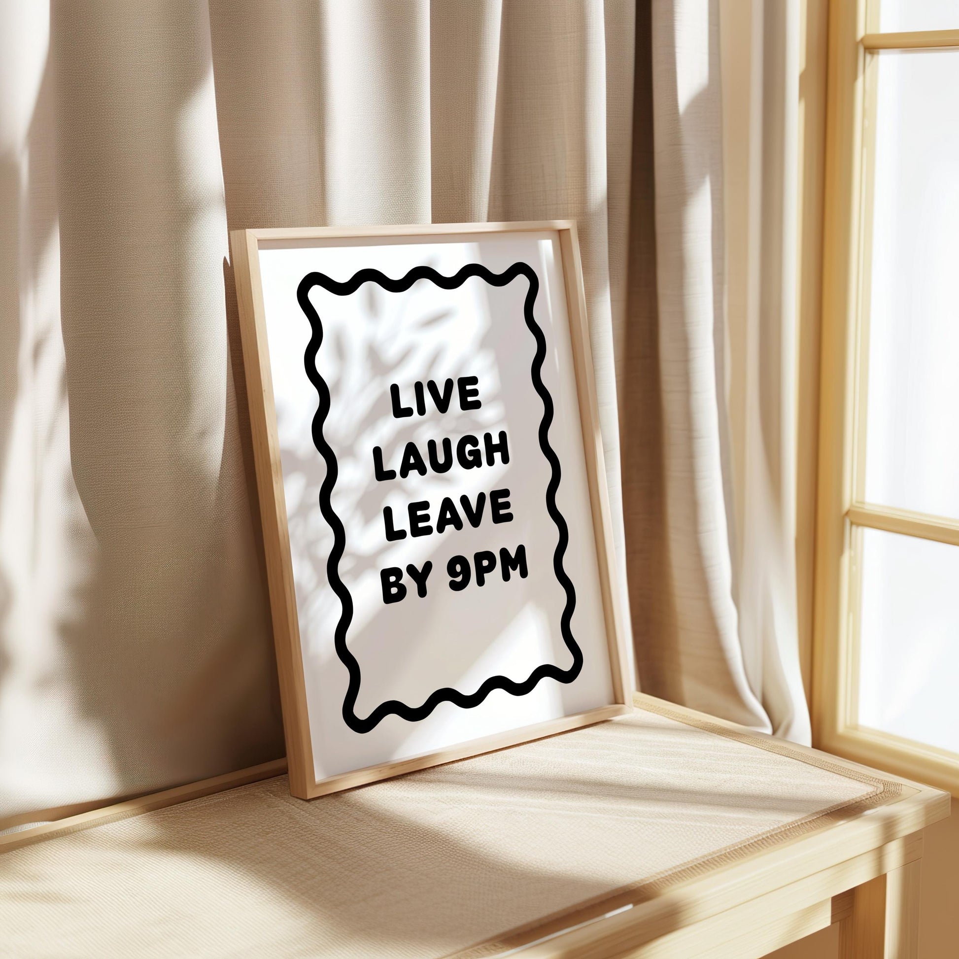 Bold black and white typography poster featuring the phrase “Live Laugh Leave By 9pm” framed by a wavy border. Minimalist modern design perfect for living rooms, hallways, or home offices. Funny quote wall art ideal for introverts, humour lovers, or as a witty gift for friends. Printed on premium satin paper, made in the UK by Hues & Reflections.