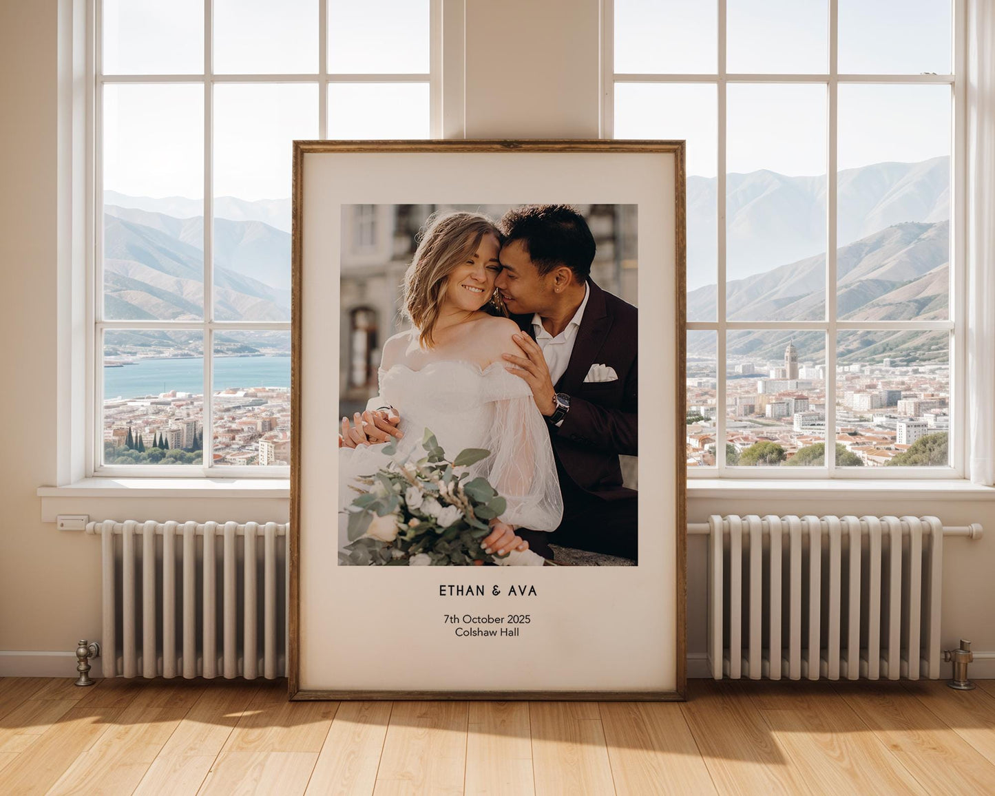 A personalised wedding photo print featuring a couple on their wedding day in elegant natural light. The bride wears an off-shoulder white gown and holds a soft green and white bouquet while the groom embraces her. Minimal modern layout with names, wedding date and venue below the image. A stylish custom keepsake for couples, weddings, anniversaries or home decor.