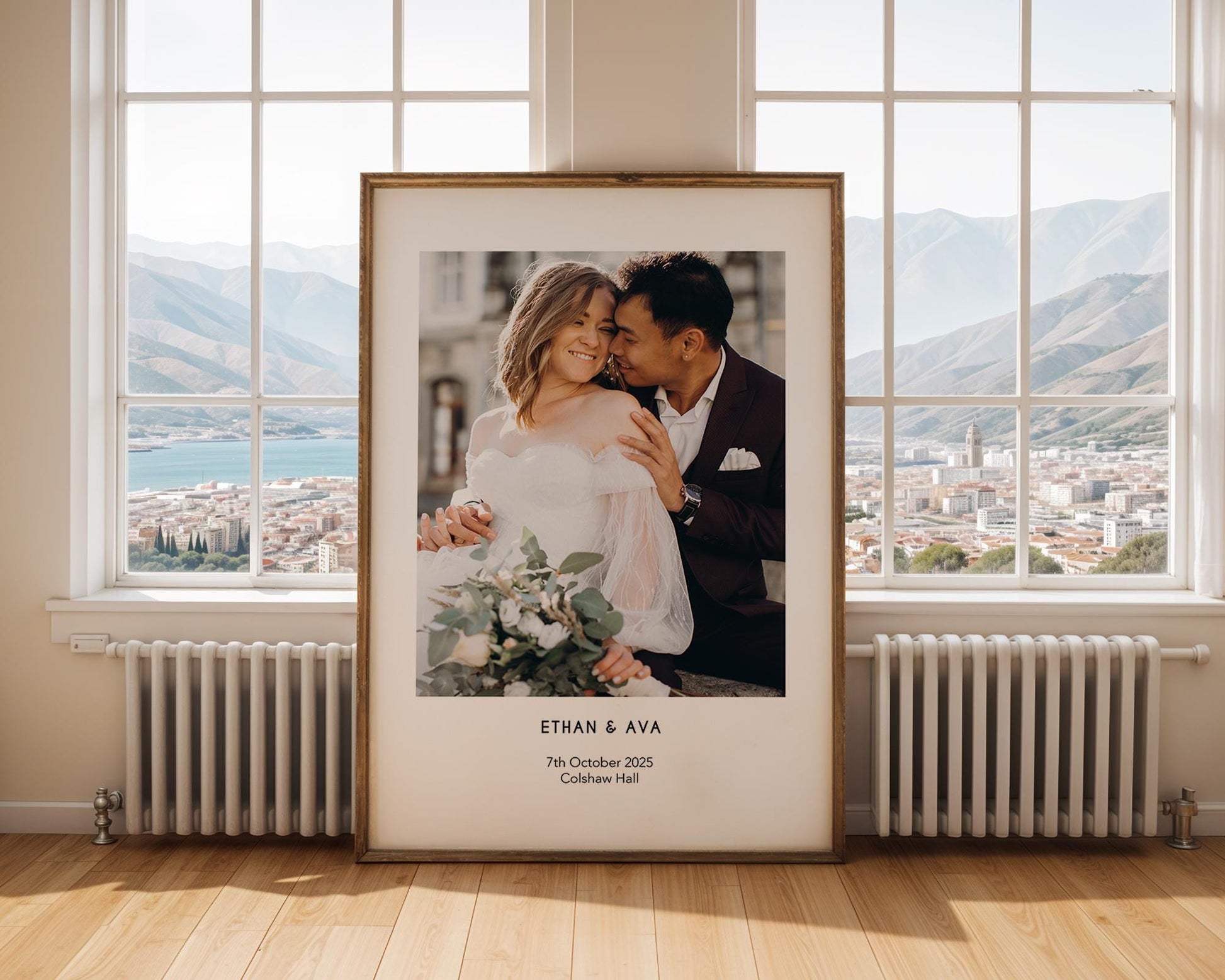 A personalised wedding photo print featuring a couple on their wedding day in elegant natural light. The bride wears an off-shoulder white gown and holds a soft green and white bouquet while the groom embraces her. Minimal modern layout with names, wedding date and venue below the image. A stylish custom keepsake for couples, weddings, anniversaries or home decor.