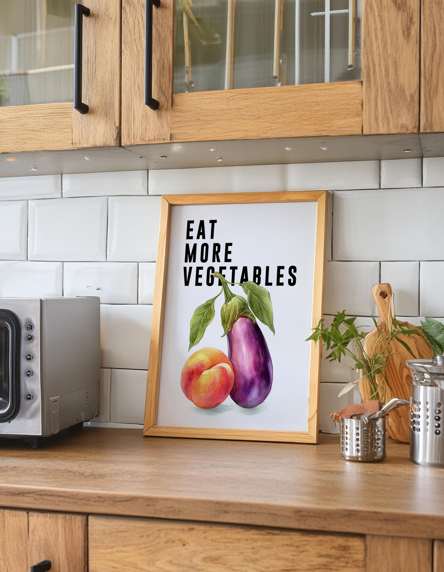 Playful food-themed wall art featuring bold black typography reading “Eat More Vegetable” above a colourful illustration of an aubergine and peach. Modern humorous kitchen poster with a cheeky twist, perfect for kitchens, dining rooms, or as a fun gift for friends. Printed to order on premium satin photo paper by Hues & Reflections UK.