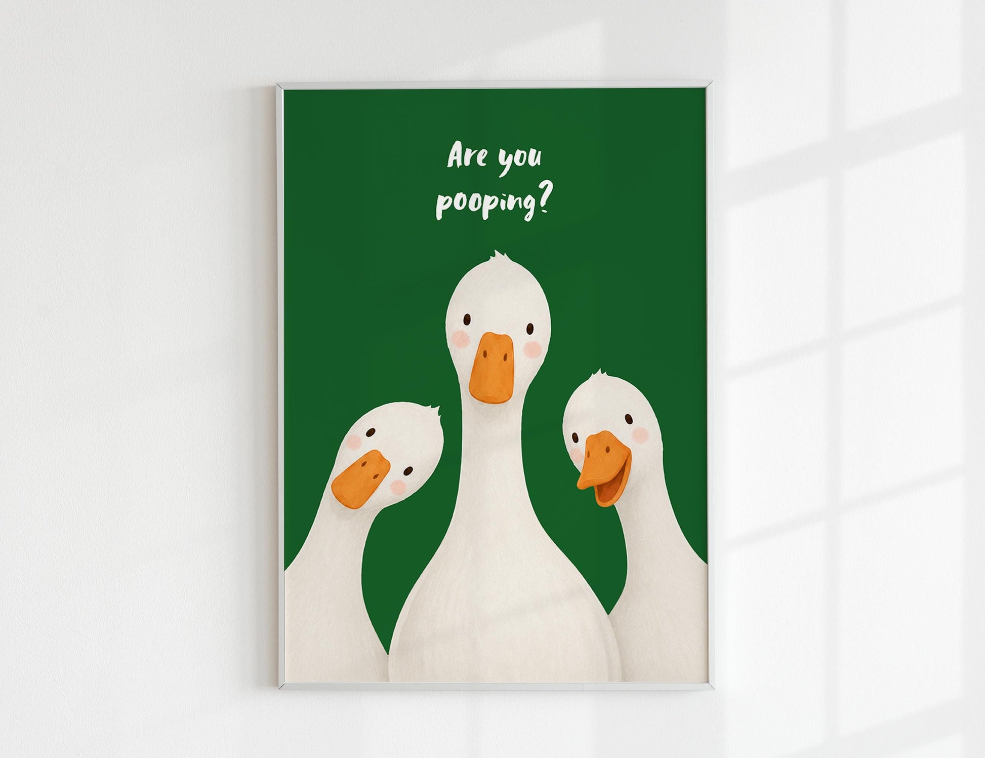Are You Pooping print, funny bathroom wall art featuring three cute white geese with orange beaks and rosy cheeks on a soft coloured background, whimsical illustrated toilet humour poster also loved as duck art and silly goose art, available in 11 colours including pink jade olive yellow forest green blue sky blonde blue dusk grey claret indigo and white, perfect housewarming gift for powder rooms guest bathrooms and quirky interiors, printed on premium 260gsm satin lustre paper