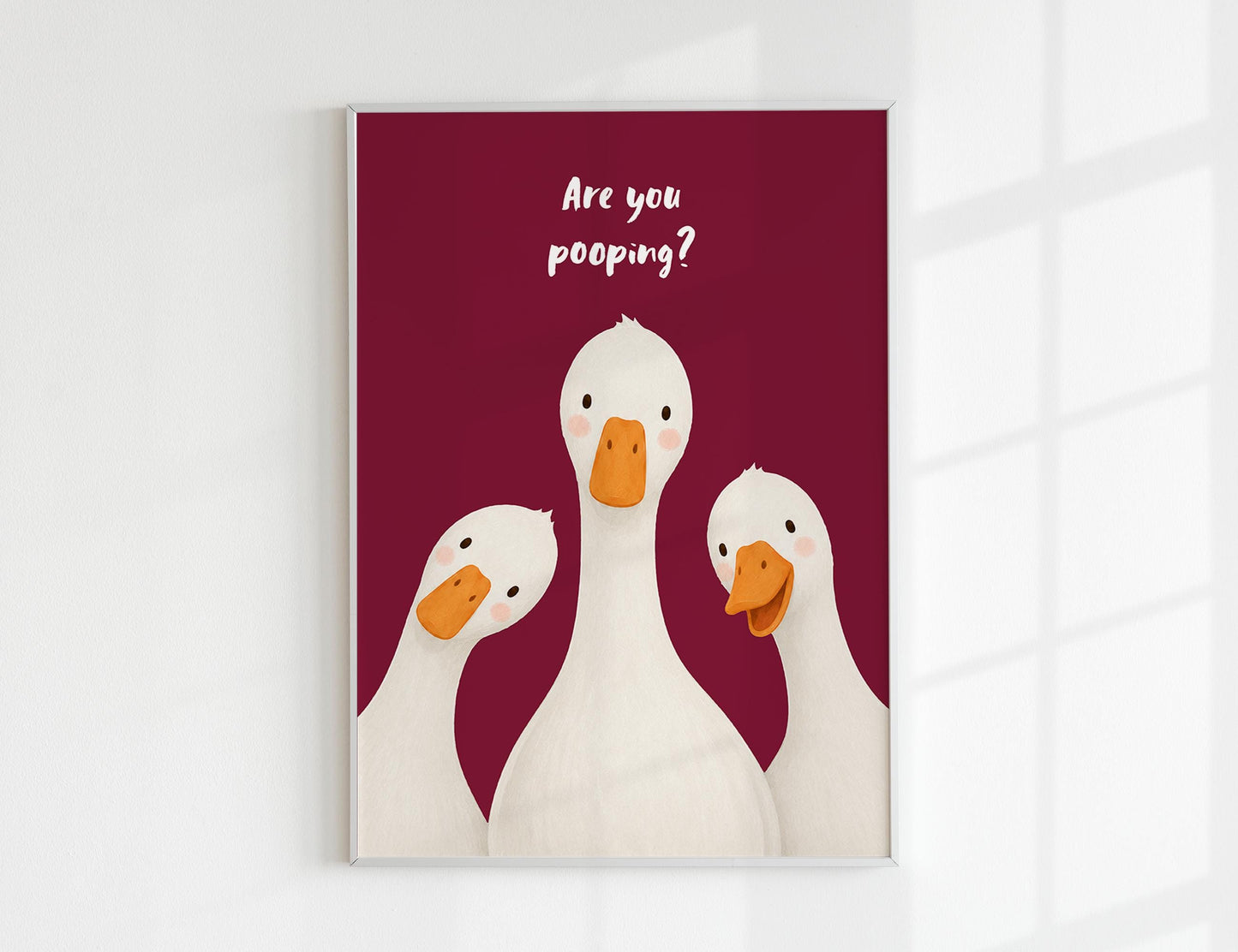 Are You Pooping print, funny bathroom wall art featuring three cute white geese with orange beaks and rosy cheeks on a soft coloured background, whimsical illustrated toilet humour poster also loved as duck art and silly goose art, available in 11 colours including pink jade olive yellow forest green blue sky blonde blue dusk grey claret indigo and white, perfect housewarming gift for powder rooms guest bathrooms and quirky interiors, printed on premium 260gsm satin lustre paper