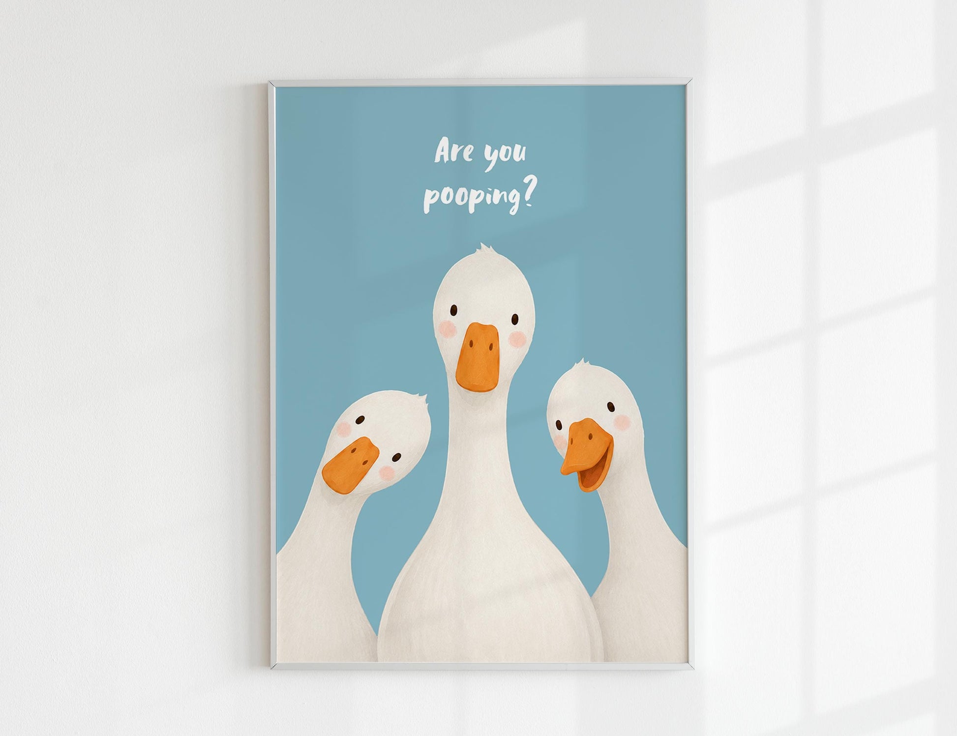 Are You Pooping print, funny bathroom wall art featuring three cute white geese with orange beaks and rosy cheeks on a soft coloured background, whimsical illustrated toilet humour poster also loved as duck art and silly goose art, available in 11 colours including pink jade olive yellow forest green blue sky blonde blue dusk grey claret indigo and white, perfect housewarming gift for powder rooms guest bathrooms and quirky interiors, printed on premium 260gsm satin lustre paper